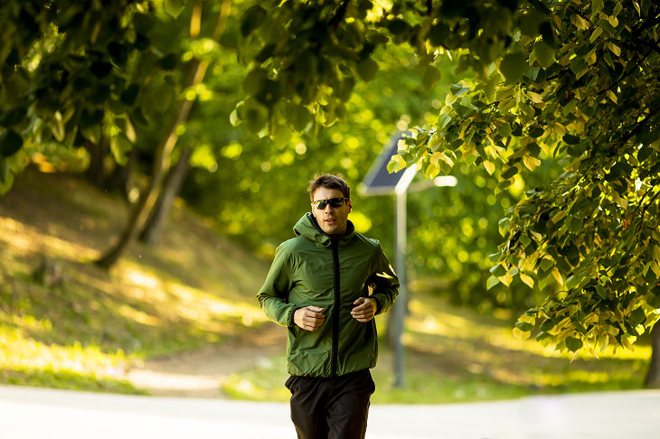 Person running surrounded by greenery