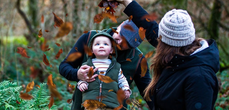 Family enjoying falling leaves at Westonbirt Arboretum